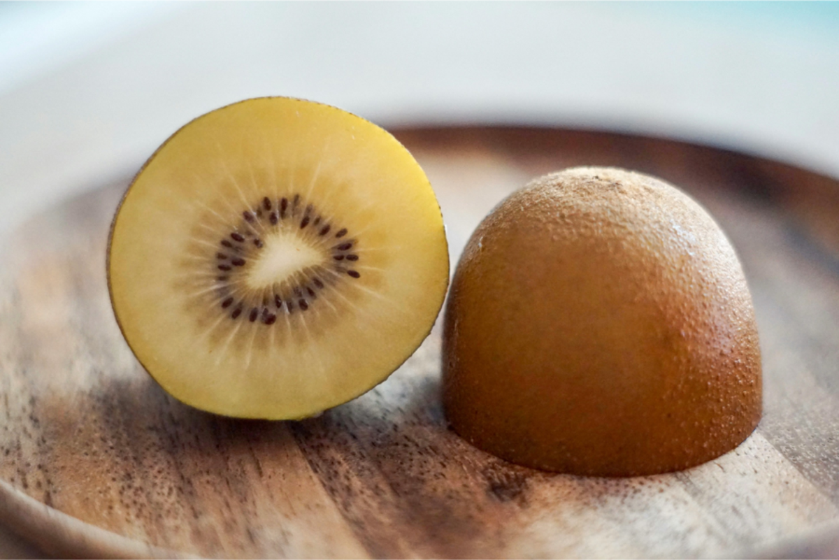 Halved Golden Kiwifruit on a wooden plate